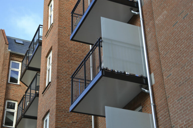 Stålaltaner med fiberbetongulv og alu loft. Stålrækværk med lodret udfyldning og hårdttræs håndliste. Varmforzinket og malet. Helgesensgade 19-21. København Ø. 200326-25